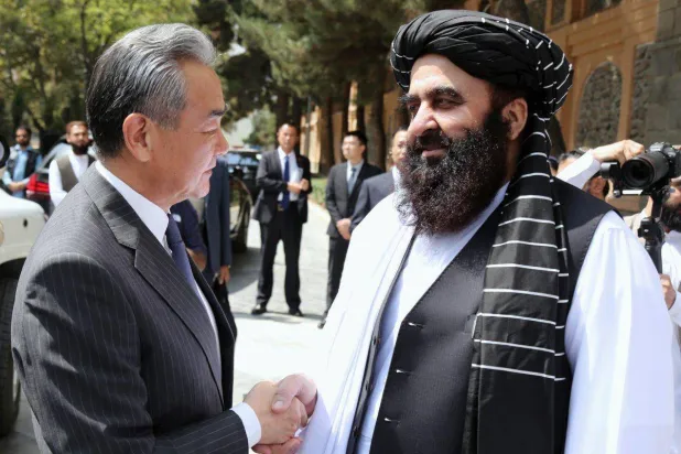 وزير الخارجية الأفغاني بالإنابة أمير خان متقي (يمين) وهو يصافح وزير الخارجية الصيني وانغ يي خلال لقائهما في كابل، يوم 20 أغسطس 2025 (إ.ب.أ)