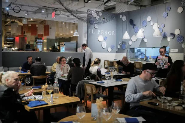 رواد بأحد مطاعم مدينة نيويورك يتناولون وجباتهم (رويترز)