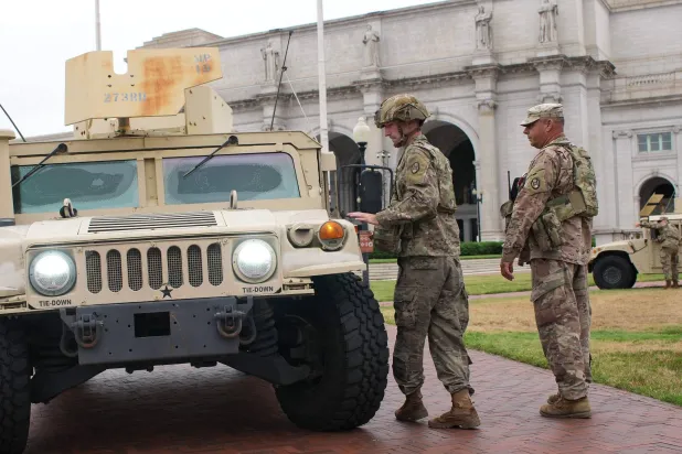 جنود من الحرس الوطني لساوث كارولينا يقفون في محيط «يونيون ستيشن» في واشنطن وبجوارهم سيارة هامفي (غيتي - أ.ف.ب) 