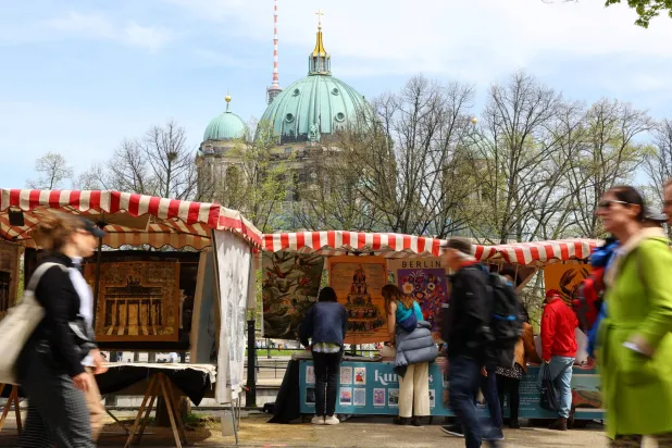 يتجول الزوار في سوق الفن ببرلين بالقرب من مبنى زوغهاوس (رويترز)