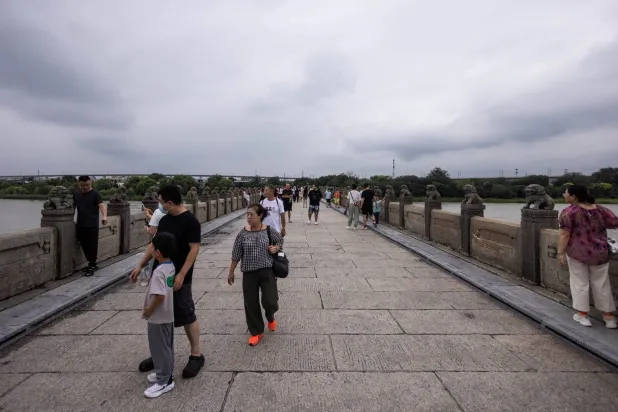 مشاة على «جسر ماركو بولو» الأيقوني في العاصمة الصينية بكين (رويترز)