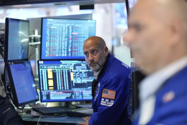 متداولون بالقرب من شاشات تعرض مؤشرات الأسهم في بورصة نيويورك (أ.ب)