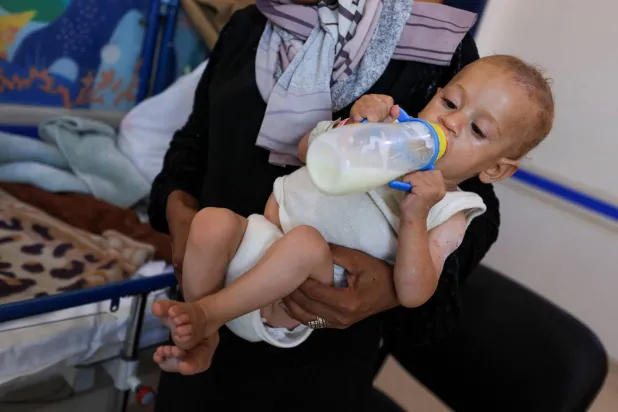 طفل فلسطيني عمره 8 شهور يتناول الحليب في مستشفى الرنتيسي في مدينة غزة (رويترز) 