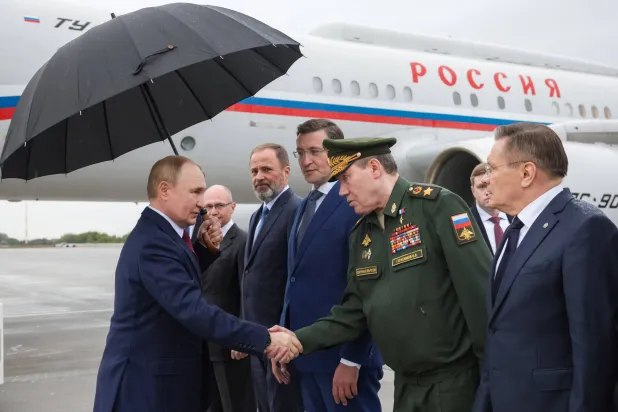 الرئيس الروسي فلاديمير بوتين يصافح رئيس الأركان فاليري غيراسيموف وبجواره أليكسي ليخاتشوف رئيس مؤسسة الطاقة النووية الحكومية (روساتوم) (الكرملين - إ.ب.أ)