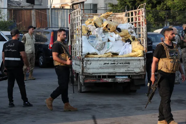 عناصر من الجيش اللبناني بمحيط شاحنة محملة بأسلحة تسلمها لبنان من حركة «فتح» الفلسطينية في مخيم برج البراجنة بجنوب بيروت (إ.ب.أ)