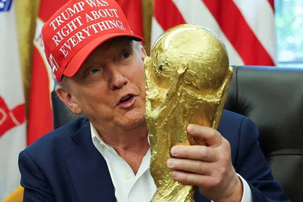 الرئيس الأميركي دونالد ترمب يحمل كأس العالم (رويترز)