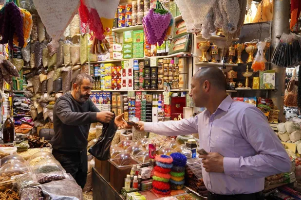 مواطن يشتري من أحد محال العطارة في مدينة دهوك بالعراق (أ.ف.ب)