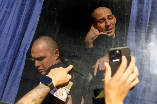 أسير أوكراني محرر يلوح بيده بينما يتحدث في مكالمة فيديو عبر الهاتف مع والدته بعد عملية تبادل في وقت سابق هذا الشهر (رويترز)