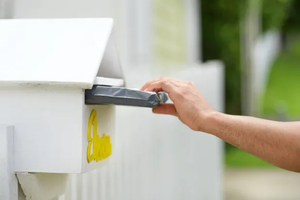 شخص يضع طرداً صغيراً في صندوق البريد (بريد نيوزيلندا عبر «فيسبوك»)