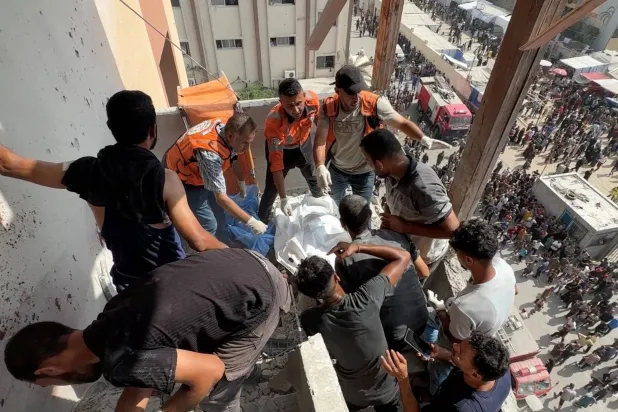 أشخاص ورجال إنقاذ يعملون على انتشال جثة المصور الفلسطيني حسام المصري وأشخاص آخرين في غارات إسرائيلية على مستشفى ناصر في خان يونس جنوب قطاع غزة، 25 أغسطس 2025 (رويترز)