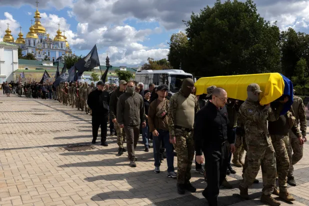  جنود أوكرانيون يحملون نعش رفيق لهم خارج دير القديس ميخائيل في كييف الاثنين وسط الهجوم الروسي على بلادهم (رويترز)