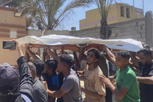 Geçtiğimiz pazar günü yardım almaya çalışırken açılan İsrail ateşiyle öldürülen yakınlarının cenazesi başında yas tutan Filistinliler (Reuters)