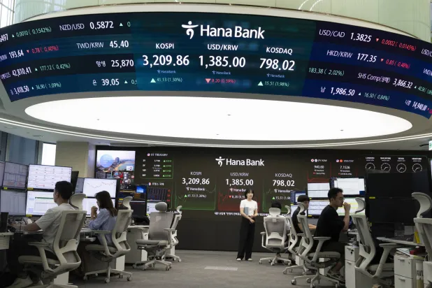 متداولون من كوريا الجنوبية يعملون أمام شاشات في بنك هانا في سيول (إ.ب.أ)