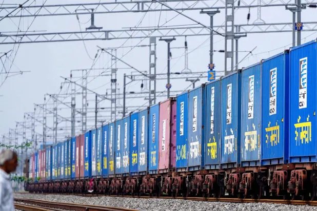 قطار شحن يحمل حاويات بضائع يسير على خط سكة حديد في أجمر الهند (أ.ف.ب)