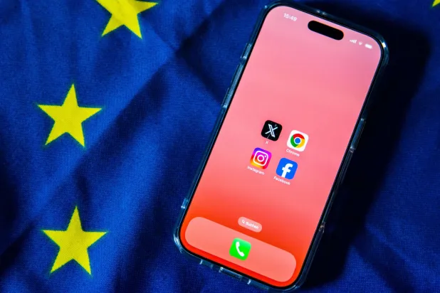 شعارات «فيسبوك» و«إنستغرام» و«إكس» و«غوغل كروم» على شاشة هاتف ذكي مُثبت على علم الاتحاد الأوروبي (د.ب.أ)