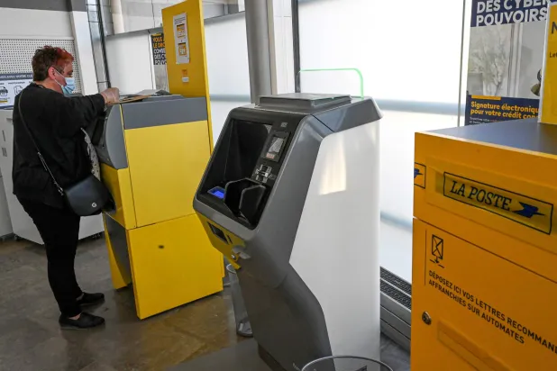 امرأة ترسل بريداً عبر أحد المكاتب في فرنسا (أ.ف.ب - أرشيفية)