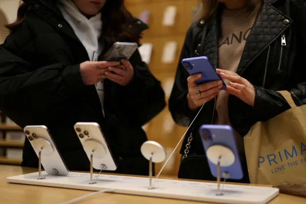 People use Apple iPhone smartphones at a store in London, Britain, October 6, 2024. (Reuters) 