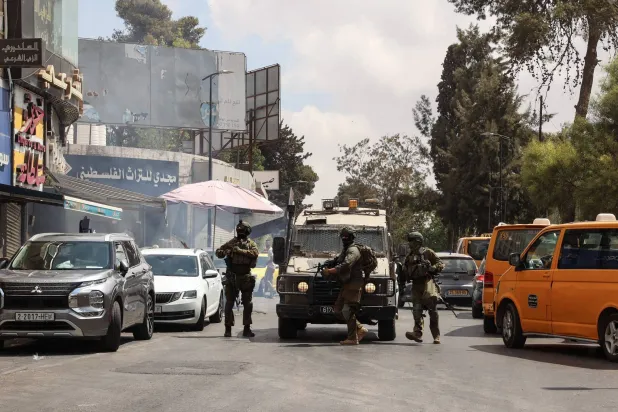 جنود إسرائيليون يغلقون طريقاً أثناء مداهمة في مدينة رام الله بالضفة الغربية (أ.ف.ب)