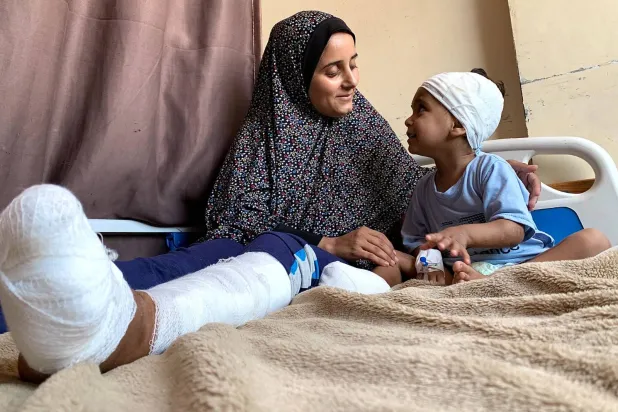 الطفل مصعب أبو محسن ووالدته في مجمع ناصر الطبي بخان يونس بعد إصابتهما في قصف إسرائيلي على خيمة العائلة (الشرق الأوسط)