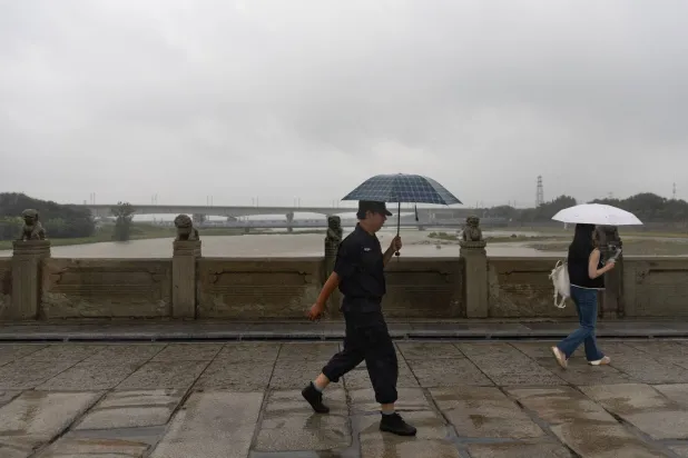 صينيون على جسر «ماركو بولو» الشهير في العاصمة بكين (إ.ب.أ)