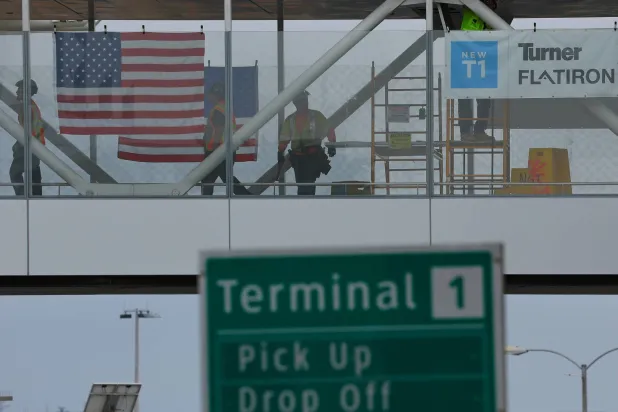 عمال بناء يقفون على ممر للمشاة في مبنى الركاب الجديد بمطار سان دييغو الدولي بكاليفورنيا (رويترز)