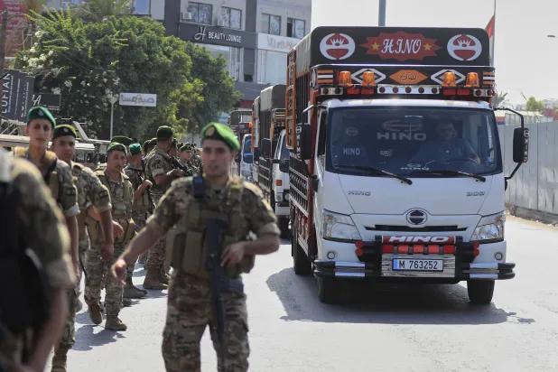 جنود من الجيش اللبناني يواكبون شاحنة تحمل أسلحة فلسطينية سلمتها «منظمة التحرير» للسلطات اللبنانية (أ.ب)