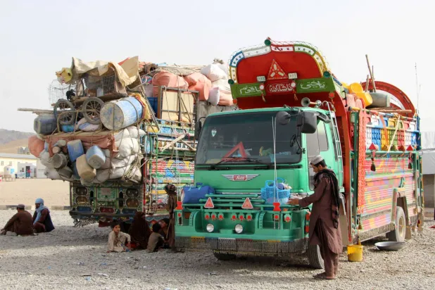 ينتظر اللاجئون العائدون من باكستان المجاورة بمخيم قبل التوجه إلى بلداتهم الأصلية في قندهار بأفغانستان الأربعاء (إ.ب.أ)