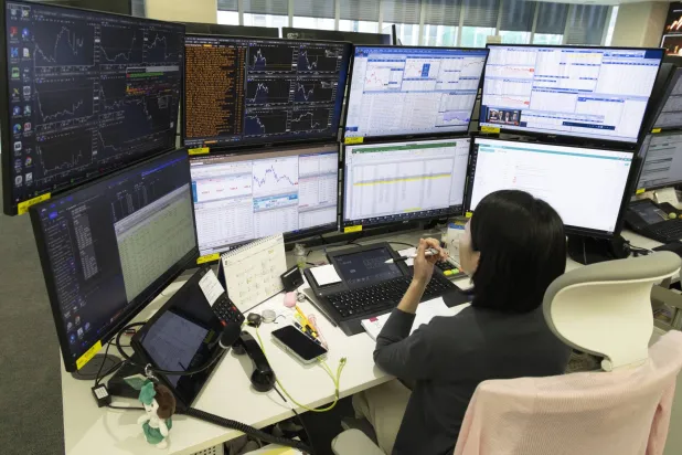 يعمل أحد المتداولين أمام شاشات المراقبة في بنك "هانا" بالعاصمة سيول (إ ب أ)