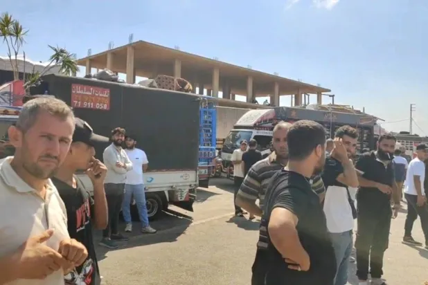سوريون ينتظرون على معبر «العريضة» خلال رحلة العودة إلى سوريا (وكالة أخبار اليوم)