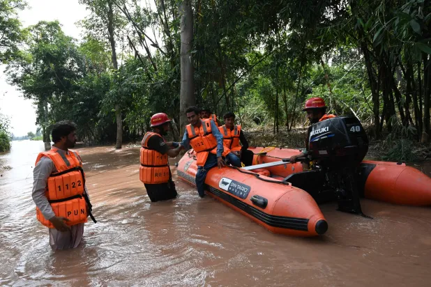 عمال إنقاذ باكستانيون يساعدون السكان على الإجلاء من المناطق التي غمرتها الفيضانات بعد ارتفاع منسوب مياه الفيضانات في نهر تشيناب بمقاطعة سرغودا بإقليم البنجاب في باكستان يوم 28 أغسطس 2025 (إ.ب.أ)