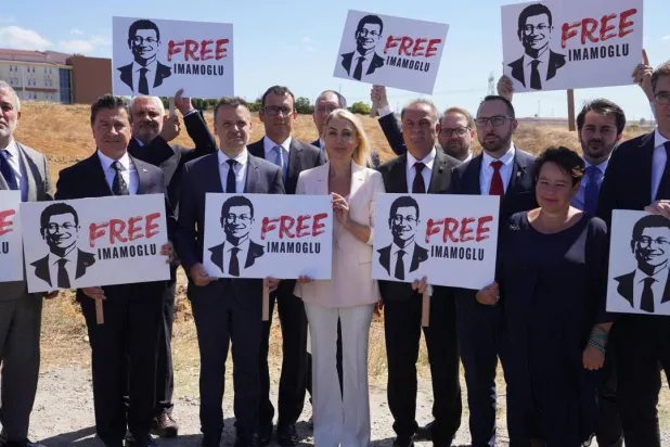 رؤساء بلديات أوروبيون يرفعون لافتات تحمل صور رئيس بلدية إسطنبول المحتجز أكرم إمام أوغلو مطالبين بإطلاق سراحه أمام سجن سيليفري بعد رفض وزارة العدل التركية زيارتهم له في سجن سيليفري (حزب الشعب الجمهوري - إكس) 