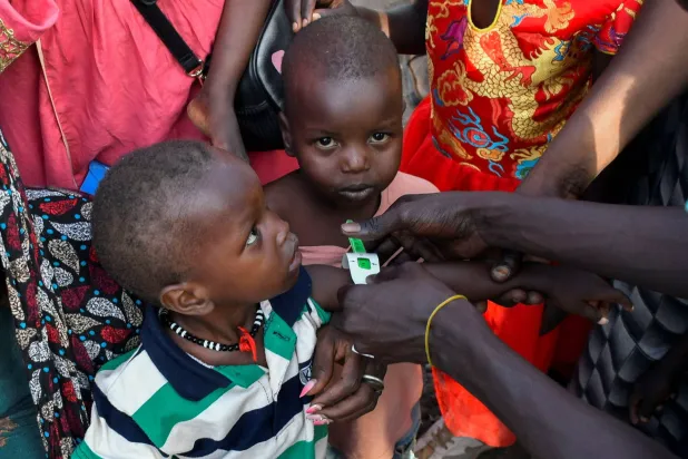 يتم فحص أطفال سودانيين بحثاً عن سوء التغذية في مفوضية الأمم المتحدة لشؤون اللاجئين بعد عبورهم عند نقطة حدود جودا الجنوبية بولاية أعالي النيل جنوب السودان (رويترز - أرشيفية)