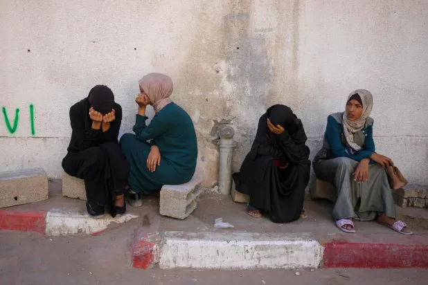 فلسطينيات يبكين أقارب لهن قُتلوا بالقصف الإسرائيلي خارج مستشفى «الشفاء» بمدينة غزة الجمعة (أ.ف.ب)