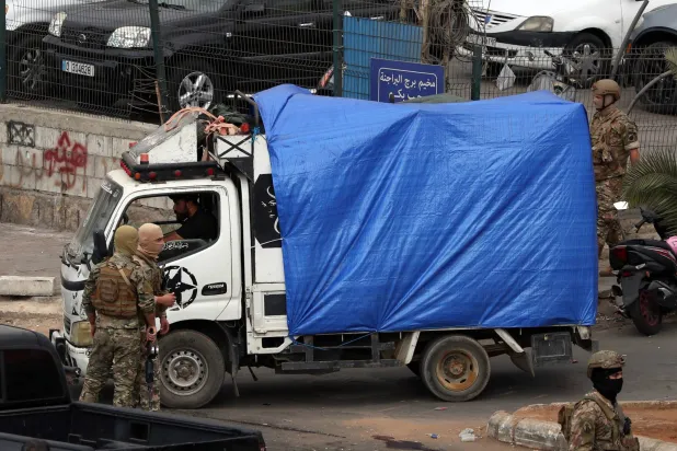 جنود لبنانيون يقفون بجوار شاحنة تحمل أسلحة من أحد المخيمات الفلسطينية جنوب بيروت (إ.ب.أ)