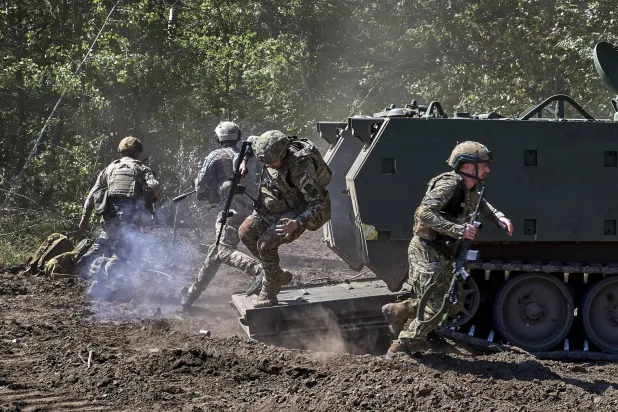 جنود أوكرانيون من الحرس الوطني يخرجون من مدرعة أميركية طراز M113 خلال تدريبات بمنطقة خاركيف (إ.ب.أ)