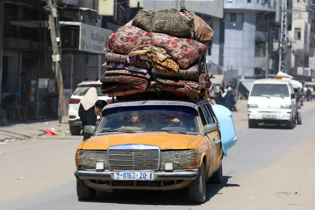 فلسطينيون ينقلون أمتعتهم من مكان إلى آخر في غزة بحثاً عن الأمان (رويترز)