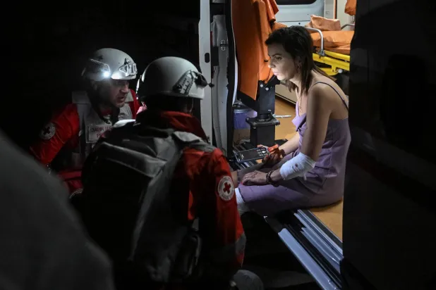 مسعفون يقدمون رعاية طبية لمصابة في قصف روسي استهدف منطقة زابوريجيا (رويترز)