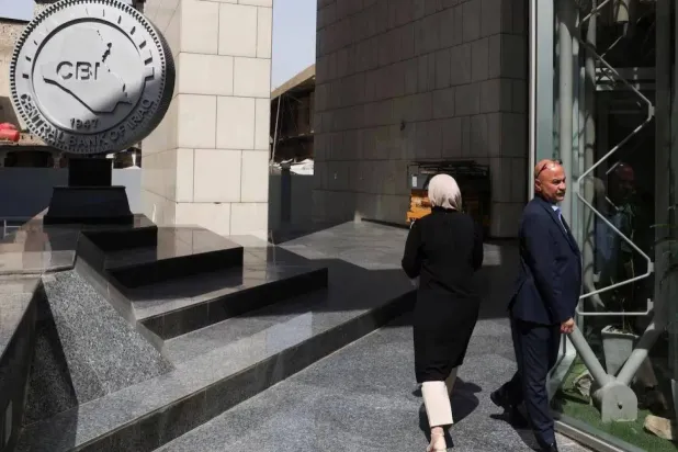 موظفون يسيرون في مقر البنك المركزي العراقي ببغداد (رويترز)