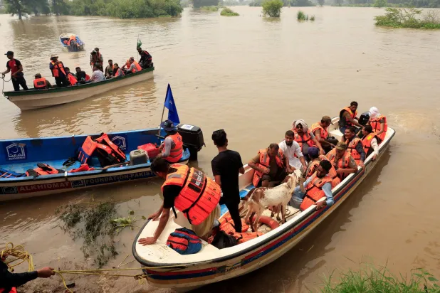 قوارب إنقاذ تجلي أفراداً من مناطق غمرتها المياه في البنجاب (رويترز)