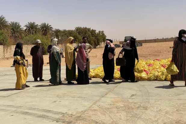 من عمليات توزيع مساعدات على النازحين السودانيين في الكفرة الليبية (المكتب الإعلامي للبلدية)