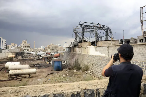 مصور يمني في صنعاء يوثق آثار ضربة إسرائيلية لمحطة وقود (إ.ب.أ)