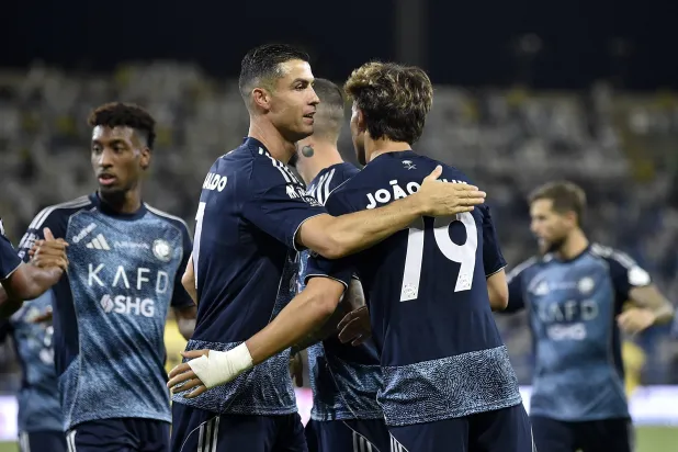 فيليكس يتلقى تهنئة رونالدو عقب أحد أهدافه أمام التعاون (رويترز)