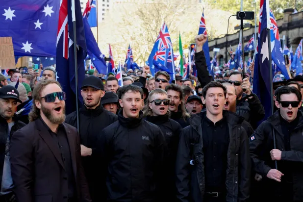 متظاهرون يحملون أعلاماً أسترالية خلال «مسيرة من أجل أستراليا» المناهضة للهجرة في سيدني بأستراليا (رويترز)