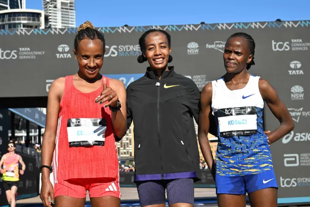 سيفان حسن خلال التتويج وبجانبها الكينية بريجيد كوسغي والإثيوبية ووركنش إديسا (أ.ف.ب)