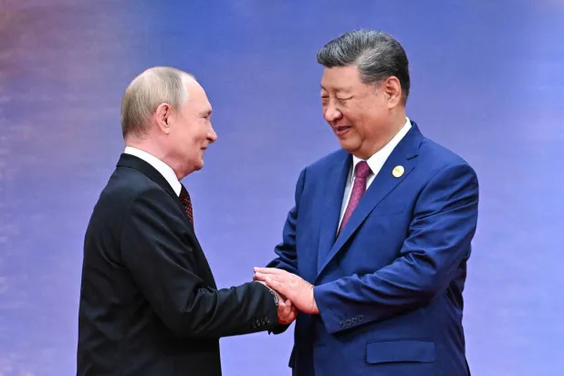 الرئيس الصيني شي جينبينغ مستقبلا نظيره الروسي فلاديمير بوتين في تيانجين أمس (د.ب.أ)