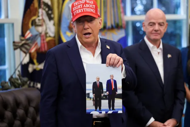 Oval Ofis'te ABD Başkanı Donald Trump, Rusya Devlet Başkanı Vladimir Putin'in kendisine hediye ettiğini söylediği fotoğrafı gösterdi (Reuters)