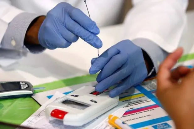 Teksas'ta kolesterol seviyelerini ölçmek için bir cihaz kullanan bir doktor (Reuters)