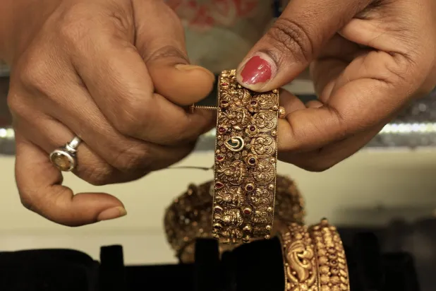 امرأة هندية تُجرّب حُلياً ذهبية في متجر مجوهرات في بنغالور - الهند (إ.ب.أ)