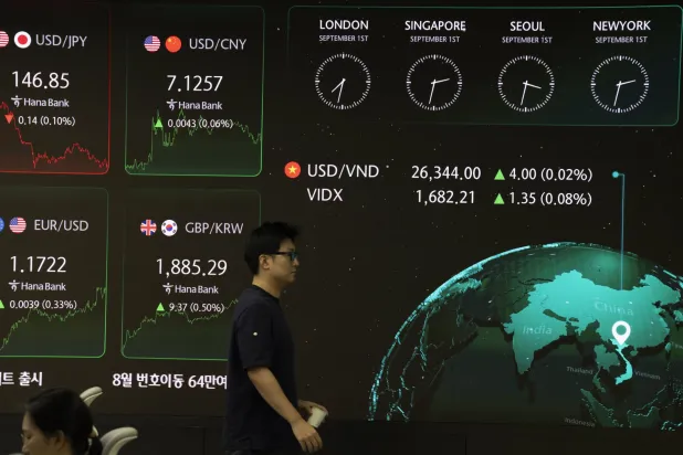 متداول يمر أمام شاشات في بنك «هانا» بالعاصمة سيول (إ.ب.أ)