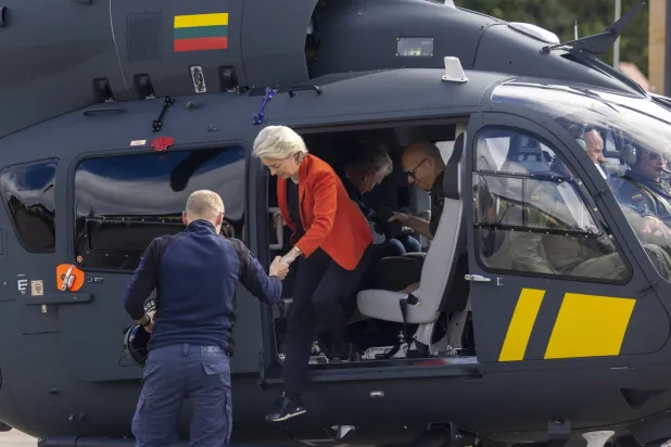 رئيسة المفوضية الأوروبية أورسولا فون دير لايين تخرج من طائرة مروحية عقب تفقدها الحدود بين ليتوانيا وبيلاروسيا (أ.ف.ب)